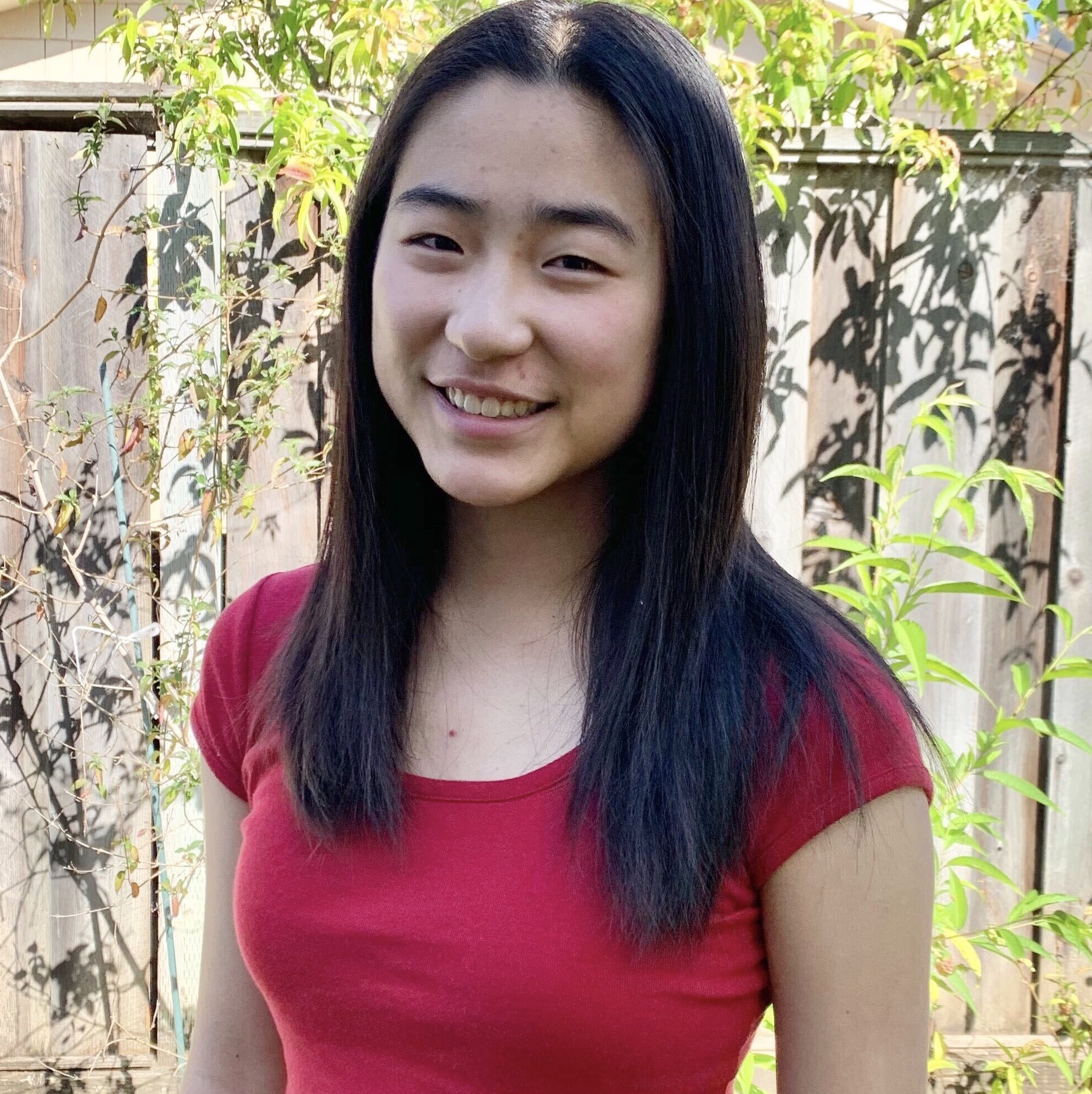 Anna standing in front of a fence
