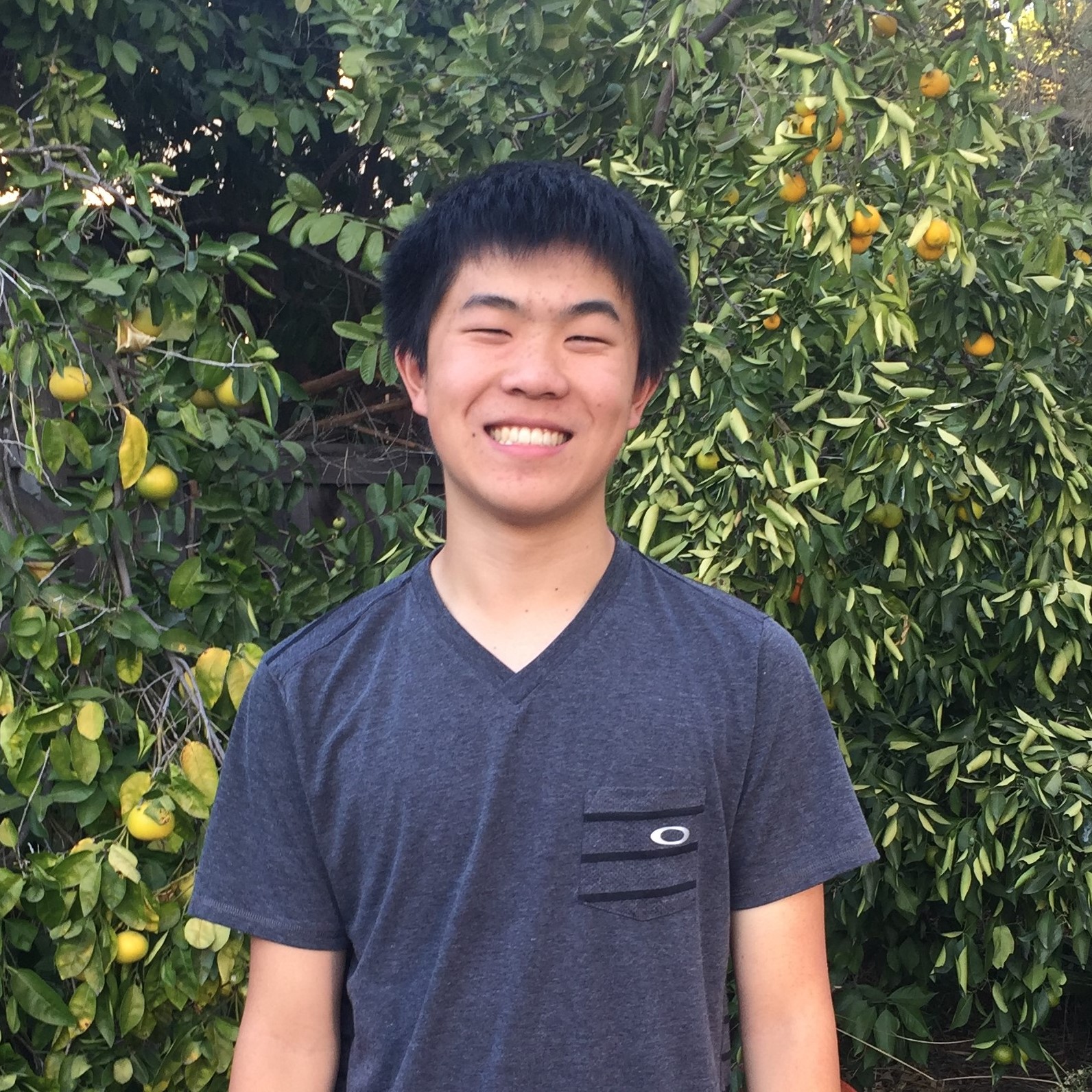 Arvin smiling while standing in front of a tree