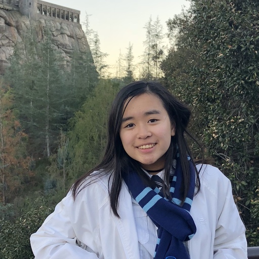 Nhi standing in front of a bush